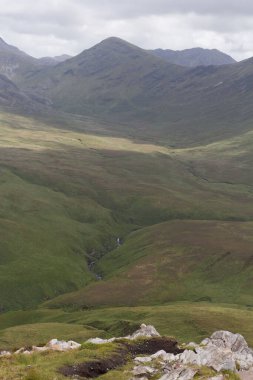 Bulutların altındaki vahşi bir İrlanda sahilinin dikey çekimi.