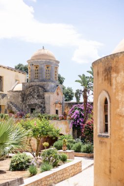 Yunanistan 'daki antik Agia Triada Manastırı' nı çevreleyen mavi gökyüzünün altında dikey bir yeşillik.