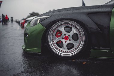 Dışarıya park edilmiş yeşil ve siyah spor arabanın yan görüntüsü.