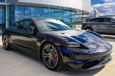 Dışarıya park edilmiş yepyeni bir Porsche Taycan.