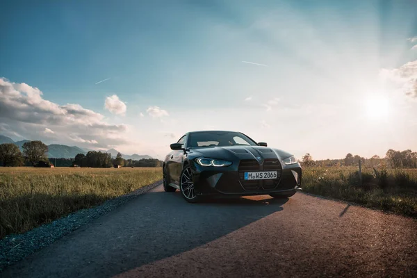 Günbatımında modern bir BMW M4 'ün, Dağ v. lüks spor arabalı görüntüsü birçok sürücünün hayalindeki arabadır.