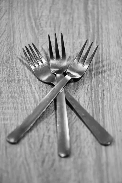 Vertical Grayscale Shot Three Silver Forks Wooden Table — Photo