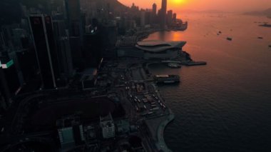 Gün batımında Hong Kong 'un liman ve şehir manzarası.