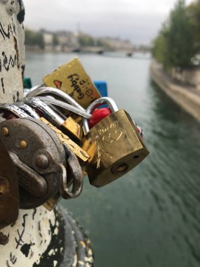 Paris, Fransa 'da bir nehirdeki köprüde asılı duran kilitlerin dikey yakın çekimi