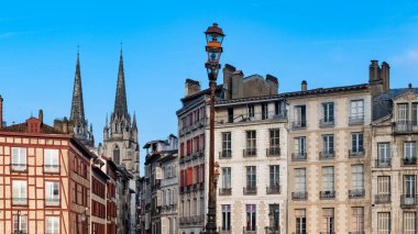 Bayonne Bask 'ta, tipik bir ön cephe, tarihi merkezde renkli panjurlar, arka planda Sainte-Marie katedrali.