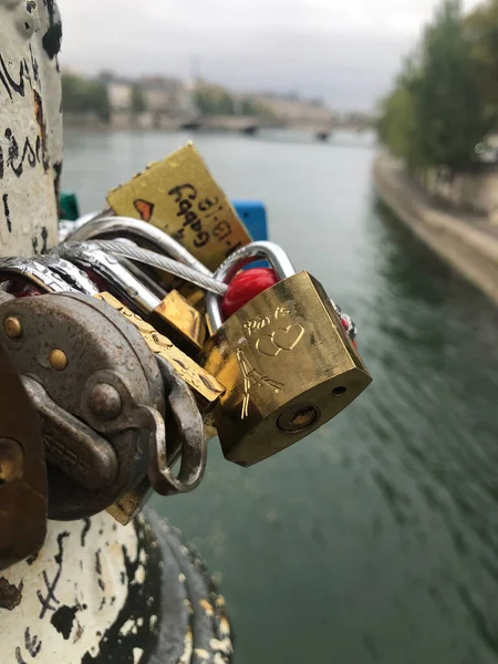 Paris, Fransa 'da bir nehirdeki köprüde asılı duran kilitlerin dikey yakın çekimi