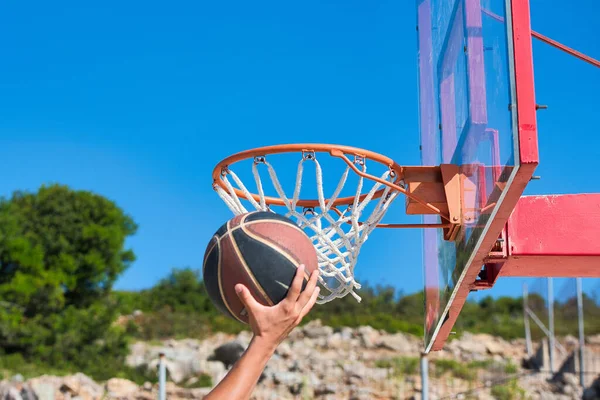 basketball ball on an outdoor basketball court, after basketball player shot