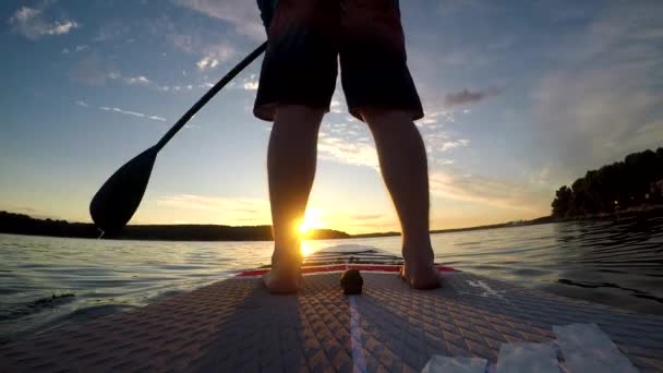 在日落背景上划船的人的脚的特写 — 图库视频影像