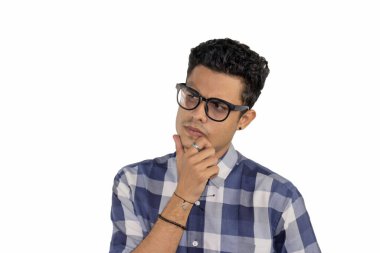 Gözlüklü genç bir İspanyol erkek beyaz bir arka planda düşünce ifadesi takınıyor.