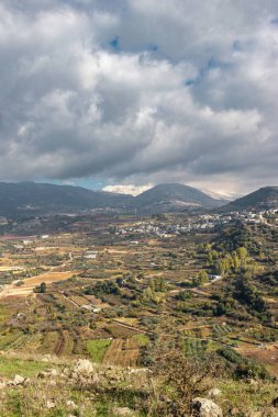 Bulutlu bir gökyüzünün altında güzel bir manzaranın dikey çekimi