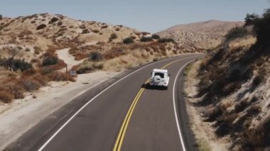 Palmdale Çölü 'nde beyaz bir Mercedes-Benz G sınıfı arabanın insansız hava aracı görüntüsü.