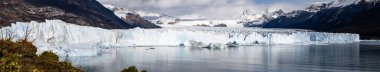 El Calafate, Arjantin 'deki karlı dağların yakınlarındaki suda buzdağlarının ve buzulların panoramik görüntüsü.