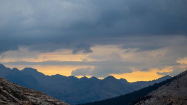 A beautiful scene of the  John Muir Trail mountain range at sunset with gloomy sky in California