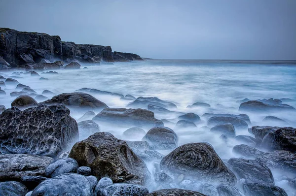 バーレン石灰岩の海岸で嵐の曇りの日 波が行ったり来たりするので 新興の岩を生み出す遅いシャッタースピード — ストック写真