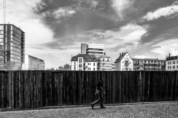 A grayscale of a construction site with a fence in foreground in Freiburg, Germany