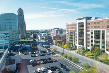 A beautiful cityscape view with modern office buildings and a parking area on a sunny day
