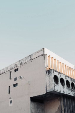 Gökyüzünün altındaki beyaz ve modern bir binanın dikey görüntüsü.