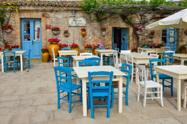A close-up shot of tables of an outdoor restaurant in Marzameni, a village in Sicily, Italy