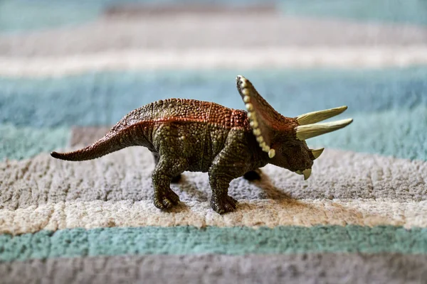 Closeup Shot Brown Triceratops Dinosaur Toy Carpet Bright Sunlight Blurred — Foto de Stock