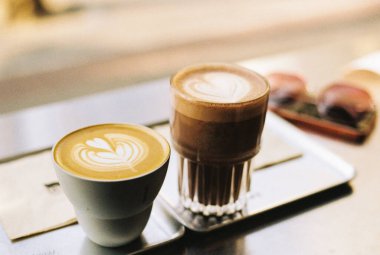 A close-up shot of two cups of cappuccino on the table