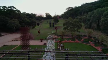 A drone flying through a small valley with large art installations
