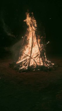 A vertical shot of a burning bonfire on a field