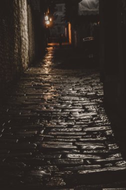A vertical shot of a narrow alley at night in Pula, Croatia