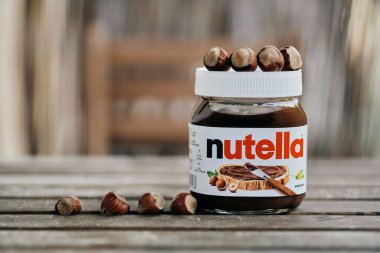 Tahta masaya serilmiş bir kavanoz Fererro Nutella fındığı.