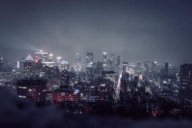 A panoramic view of an illuminated city on a foggy night