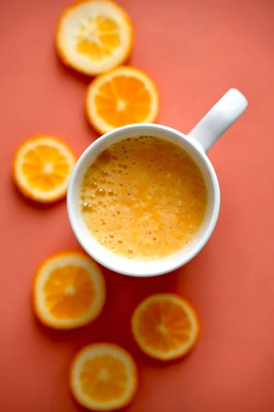 新鲜橙汁和一些桔子片的垂直顶部视图 背面是金银花色 — 图库照片