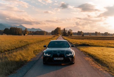 Günbatımında modern bir BMW M4 'ün, Dağ v. lüks spor arabalı görüntüsü birçok sürücünün hayalindeki arabadır.