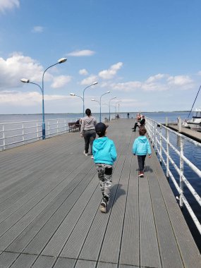 A group of people relaxing at the harbor on a sunny day, Kamien Pomorski, Poland