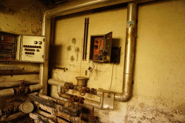 A closeup shot of industrial old pipes and controls in an abandoned room
