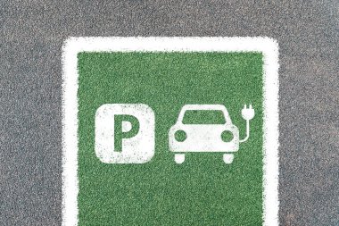 Elektrikli araba sadece sembollerle park edilir. Elektrik prizli şarj istasyonu.