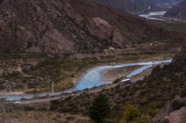 A road along the river surrounded by mountains