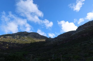 Mavi bulutlu gökyüzünün altında güzel bir tepe manzarası