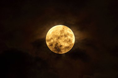 Karanlık bir gökyüzünde parlayan dolunay