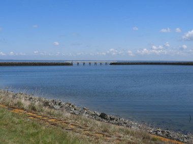 A bridge connecting two breakwaters on a sunny morning