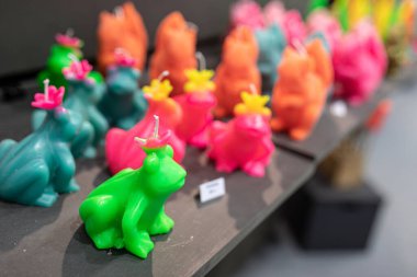 A display of colorful frog-shaped candles at BEA Expo in Bern, Switzerland