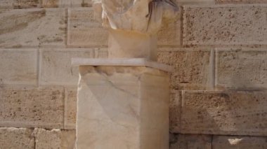 A closeup of a stone Greek statue at the Acropolis of Athens in Greece
