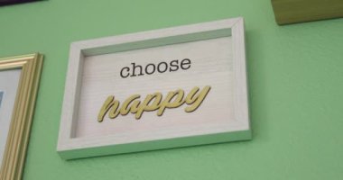 A view of a sign saying perfectly imperfect in a white frame hanging on a green wall of a spa salon