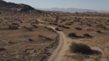 A car driving on a road surrounded by a desert