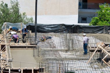 İnşaat işçileri, şehir merkezinde ev inşaatı. Beton ve beton döken özel bir tekerlek makinesinin yardımıyla. Volos Şehri, Yunanistan