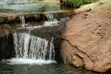 Ormanda akan kayalık bir şelalenin yakın çekimi.