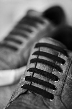 Siyah beyaz spor ayakkabılı, kullanılmış bir adamın dikey çekimi.