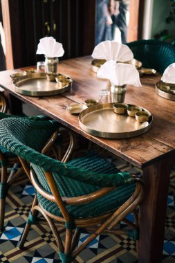 Hindistan 'da dekore edilmiş ahşap masa ve sandalyeli eski bir otelin dikey görüntüsü.