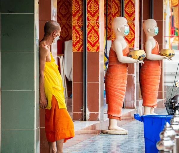 Girişin yanında rahip heykelleri olan bir Budist keşiş.