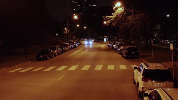 美国伊利诺伊州芝加哥的一辆汽车夜间驶过停放的汽车的航拍图 — 图库视频影像