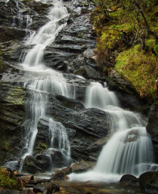 Kayaların üzerinden akan dikey bir su görüntüsü.
