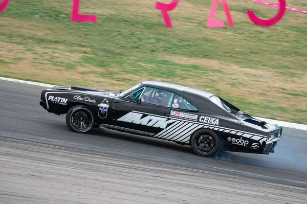 Dodge Charger yarış pistinde sürükleniyor.